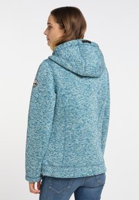 Ljusblå, texturerad fleecejacka med huva, figurformande design och en logotyp på ärmen. Har en platt krage och sömdetaljer.