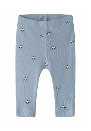 Pantalon bébé côtelé bleu clair avec petits motifs de ballons de football noirs et blancs dispersés sur le tissu.
