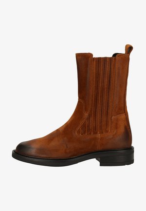 Stivale ankle in suede marrone con dettagli a righe verticali, punta rotonda, suola nera e linguetta sul retro per una facile calzata.