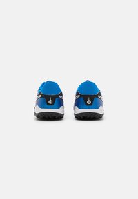 Blue athletic shoes with a textured black sole, sleek design, and reflective accents. Back view shows padded collar and distinct color block.