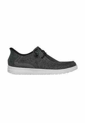 Scarpe di tela grigie con un design elegante, dettagli neri, lacci piatti e suole in gomma bianche. Caratterizzano una punta arrotondata e una parte superiore testurizzata.