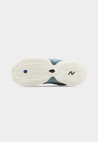 Λευκή λαστιχένια σόλα παπουτσιού New Balance που δείχνει υφασμένα σχέδια πέλματος και το λογότυπο "N" στην περιοχή του μπροστινού ποδιού.