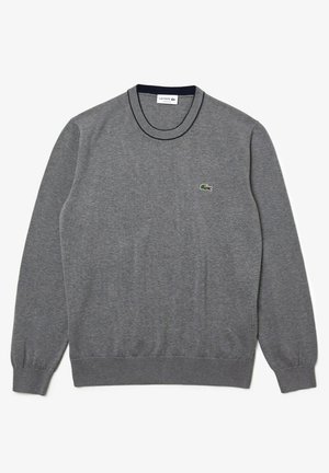 Pull gris à manches longues avec col rond, poignets et ourlet côtelés, arborant un petit logo crocodile vert Lacoste sur le côté gauche de la poitrine.