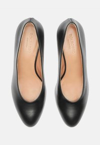 Bailarinas de cuero negro con puntera redondeada, tacón plano y una textura suave; con detalle de corte en los laterales.