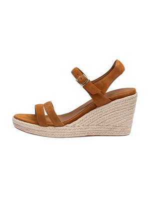 Brązowy zamszowy sandał na koturnie z paskiem wokół kostki i klamrą, z plecionym obcasem na platformie ze słomy.
