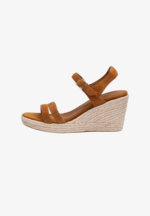 Sandale compensée en suède marron avec bride à la cheville et boucle, dotée d'un talon plateforme en paille tressée.