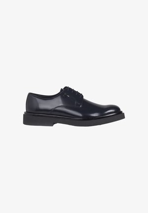 Black polished leather men's dress shoe with thick rubber sole and lace-up closure, shown from the outer side on a white background.
