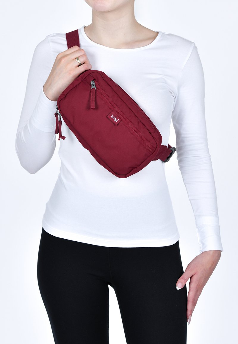 Borsa a tracolla marrone realizzata in tessuto resistente, con due scomparti con zip, tracolla regolabile e un piccolo'etichetta con logo.
