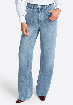 Wide-leg blue denim jeans with a high waistband, featuring front pockets and a faded wash. Material is thick with visible seams.