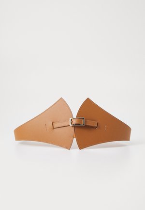 Ceinture en cuir tan avec une forme unique, ornée d'extrémités pointues, d'une boucle centrale ajustable et de détails de couture visibles.