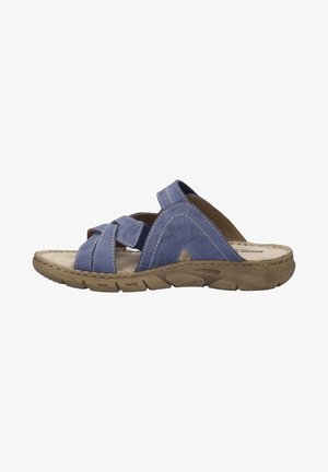 Blue leather sandal featuring crisscross straps, stitched accents, and a cushioned beige insole with a textured brown rubber sole.