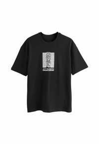 Sort bomulds t-shirt med et hvidt grafisk print af bølgede linjer og teksten "JOY DIVISION UNKNOWN PLEASURES" i et rektangulært design.