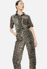 Mono de leopardo con mangas cortas, cierre de botones en la parte delantera y dos bolsillos en el pecho. Fabricado con un material ligero, cuenta con una cintura ceñida.
