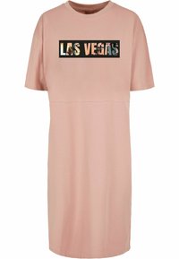 Rochie roz cu mânecă scurtă, din material de bumbac moale, având un grafic negru "LAS VEGAS" pe partea din față. Are un croi simplu, lejere, cu o siluetă dreaptă.