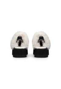 Pantofole nere con piattaforma, dotate di un soffice rivestimento in pelliccia sintetica bianca, con un'esterno in morbido camoscio e linguette nere sul retro.