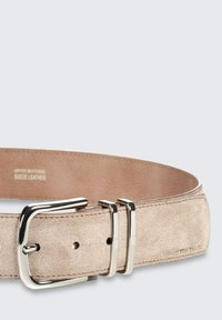 Beiger Wildledergürtel mit einer silbernen Metallschnalle mit zwei Zacken, detaillierter Naht und verstellbaren Löchern für die Größenanpassung.