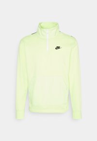 Neongrön Nike-pullover med hög krage, halvdragkedja fram, långa ärmar och en framficka. Svart logotypaccent på bröstet.