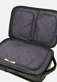 Borsa in tessuto nero, design con zip e interno grigio caratterizzato da un motivo ripetuto con il logo "GUESS". Include due tasche con zip per l'organizzazione.