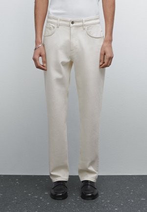 Beige gerade geschnittene Hose aus Baumwollmischgewebe, mit vorderen Taschen, Gürtelschlaufen und einem einzelnen Knopfverschluss.