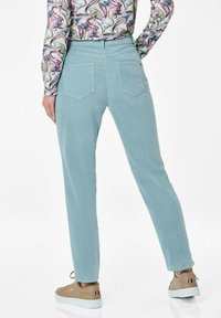 Lichtblauwe corduroy broek met een rechte snit, voorzien van twee achterzakken en een subtiele gestructureerde afwerking, gecombineerd met beige sneakers.