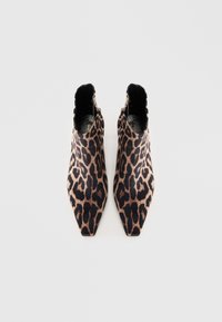 Bottes à chevilles pointues avec un motif léopard dans des nuances de brun et de noir, avec une texture de tissu douce.