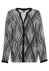 Blouse blanche et noire à manches longues avec motif géométrique en forme de losanges, boutonnage devant, et bordure noire sur le col et les poignets.