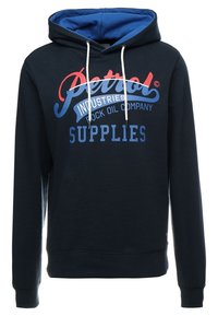 Marineblå hættetrøje med hvide snore og teksten "Petrol Industries Rock Oil Company Supplies" i rødt og blåt på brystet.