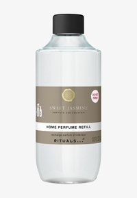 Przezroczysta szklana butelka z czarną nakrętką, oznaczona etykietą "Uzupełnienie perfum domowych Sweet Jasmine." Posiada beżowo-białą opaskę z tekstem ostrzegawczym.