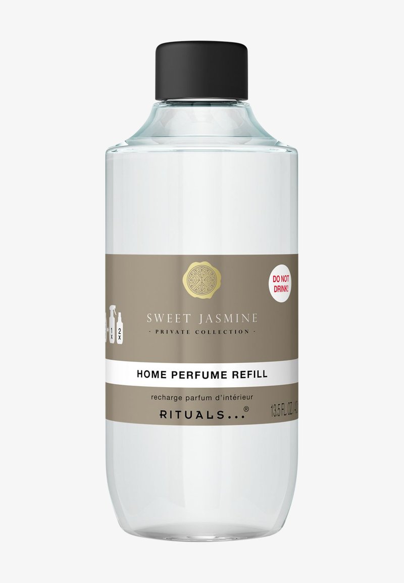 Klar glasflaska med svart kork, märkt "Sweet Jasmine Home Perfume Refill." Har ett beige och vitt band med varningstext.