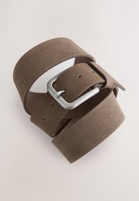 Brown perforated belt with a silver metal buckle, featuring a smooth texture and multiple adjustment holes, coiled neatly.