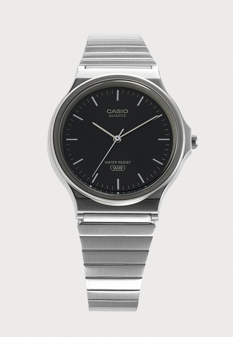 Ασημένιο ρολόι Casio με χαλαζία, μαύρο καντράν, ασημένιους δείκτες και μπρασελέ από μέταλλο, δείχνει ώρα 10:12:36.