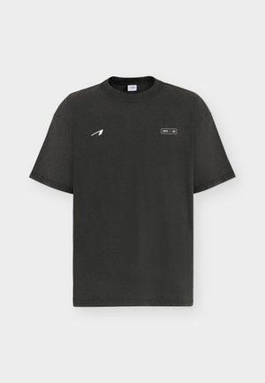 Schwarzes T-Shirt mit Rundhalsausschnitt und kurzen Ärmeln, mit kleinem weißem Pfeillogo auf der linken Brust und dem Schriftzug "CPH" in einem rechteckigen Rahmen.