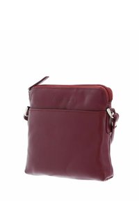 Sac en cuir bordeaux avec fermeture éclair, forme rectangulaire mince, poche avant et accents en métal argenté. Texture lisse sur toute sa surface.