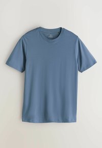 Īsām piedurknēm T-krekls gaiši zilā krāsā, izgatavots no kokvilnas maisījuma. Tam ir apaļa izgriezuma apkakle un taisna apmale, ar gludu un mīkstu tekstūru.