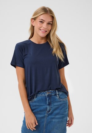 Marineblå t-shirt lavet af blødt stof, med rund hals og korte ærmer, parret med en høj talje denimnederdel.