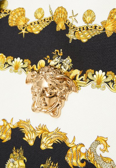Borsa in cotone bianco e nero con emblematico Medusa dorato, decorata con intricate conchiglie e motivi marini, e dettagli dorati raffinati.