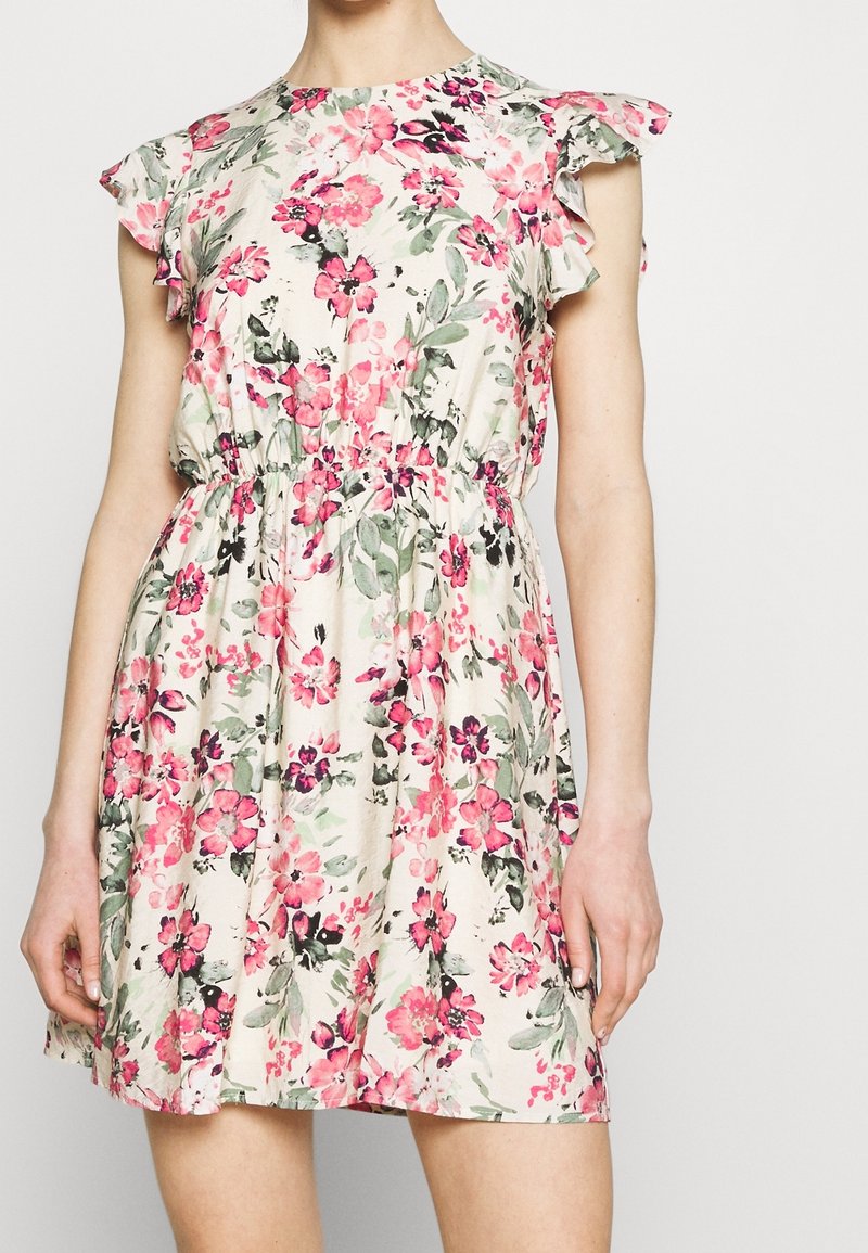 Kukkamekko, jossa on lyhyet röyhelöpaidat, kapealla vyötäröllä ja vaalean kermansävyisellä pohjalla pinkki- ja vihersävyisiä kukkakuoseja.