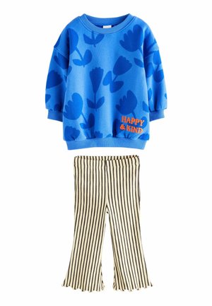 Blaues Sweatshirt mit Floral-Muster und orangefarbigem "HAPPY & KIND"-Text, kombiniert mit schwarz-weißen gestreiften Schlaghosen. Weicher Stoff.