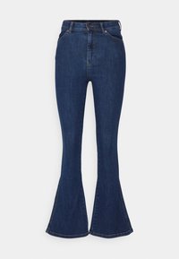 Tummansiniset farkut korkealla vyötäröllä, levenevät lahkeet, etutaskut, nappikiinnitys ja vyölenkit, esiteltynä valkoista taustaa vasten.