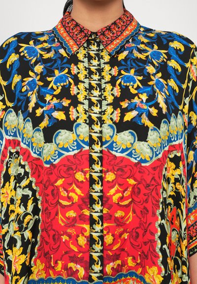 Multicolored floral blouse featuring a black base, red accents, and intricate patterns on the collar and sleeves. Smooth fabric texture.
