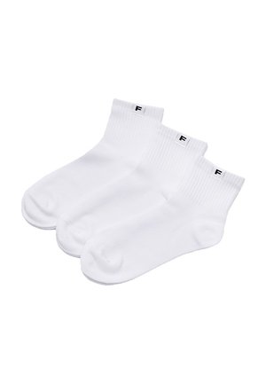 Trzy pary białych skarpetek za kostkę z prążkowanymi ściągaczami, każda z małą czarną literą "F" na białej metce u góry.