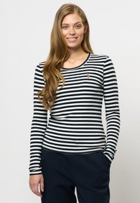 Langermet stripete topp i marineblå og hvit ribbestrikket stoff. Har rund hals og liten brodert detalj på brystet.