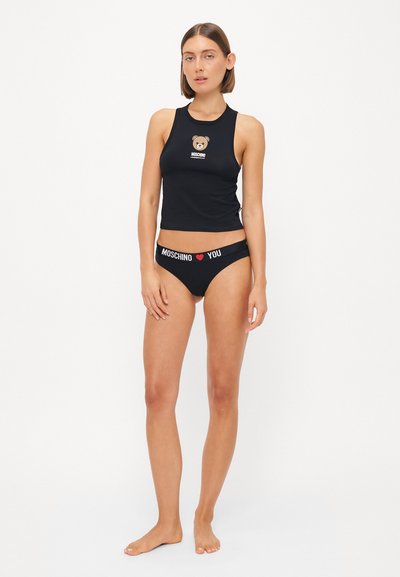 Melns bez piedurknēm crop top ar lāča grafiku un logo, saskaņots ar melnām apakšbiksēm ar baltu logo joslu. Gluda, elastīga auduma.