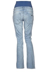 Jeans de mezclilla azul claro con diseño de pierna acampanada, que presentan bolsillos traseros y una cinturilla ancha. Textura de tela suave con un ligero desgaste.