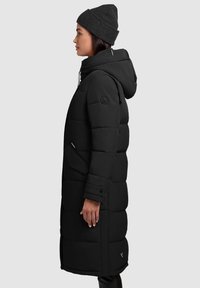 Black padded winter coat with a hood, featuring a quilted design, two side pockets, and a logo patch on the upper left arm.