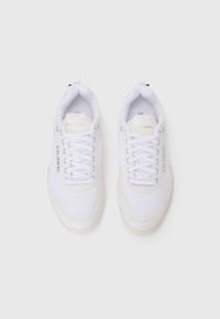 Hvide atletiske sneakers med mesh og glatte syntetiske materialer, rund tå, polstret krave og snørebånd. "Salming" logo på siden.