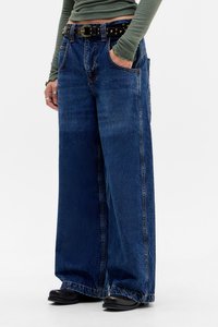 Wide-leg blue jeans made of denim with prominent stitching, five pockets, and a black studded belt at the waist.