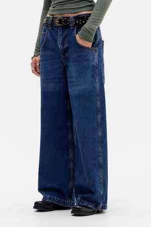 Bredde ben jeans i blå denim med fremtredende sømmer, fem lommer og et svart naglet belte i livet.