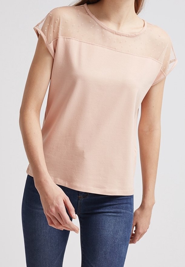 Světle růžový top s krátkým rukávem a průhledným puntíkovaným překrytím u výstřihu, měkká tkanina a volný střih. Nosené s tmavě modrými džíny.
