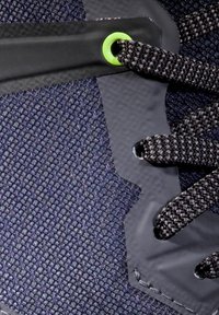 Shoe sportiv de culoare albastră închisă, cu un superior din plasă texturată, șireturi negre și detalii verzi la eyelet-uri. Dispune de un capac de vârf din cauciuc neted.
